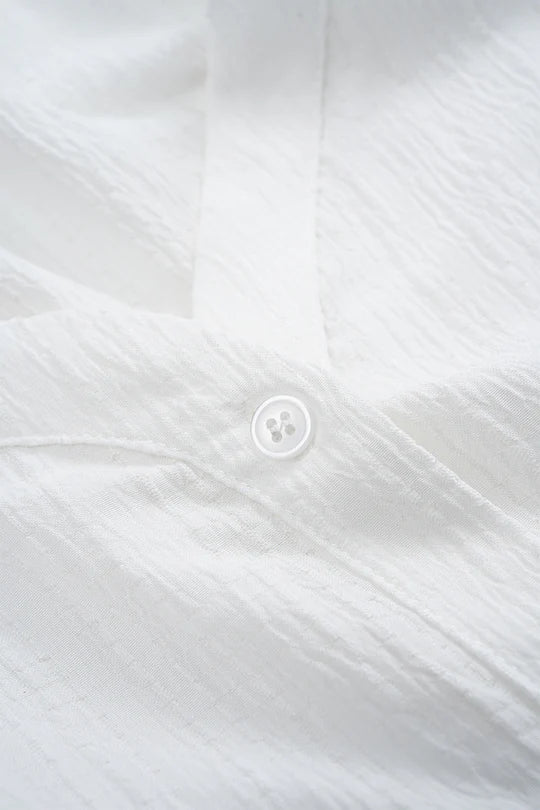 Asymmetrical sleeveless blouse with button fastening and open back