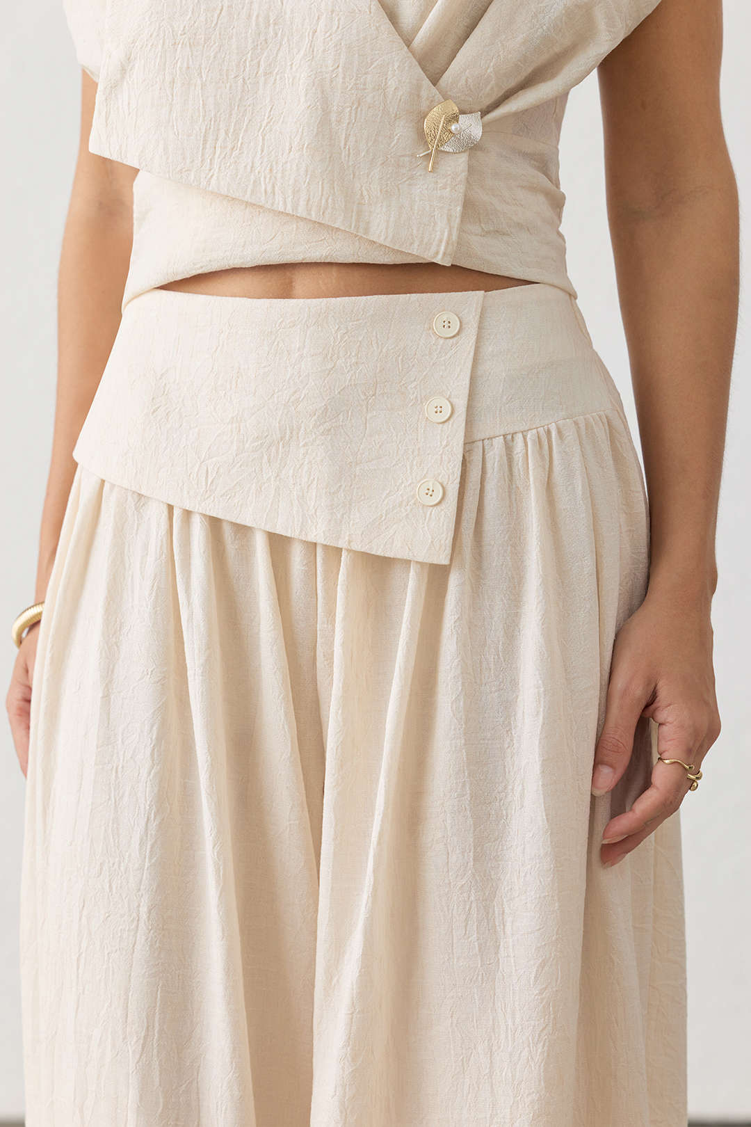 Asymmetrische broek met knoopjes, ruches en wijde pijpen
