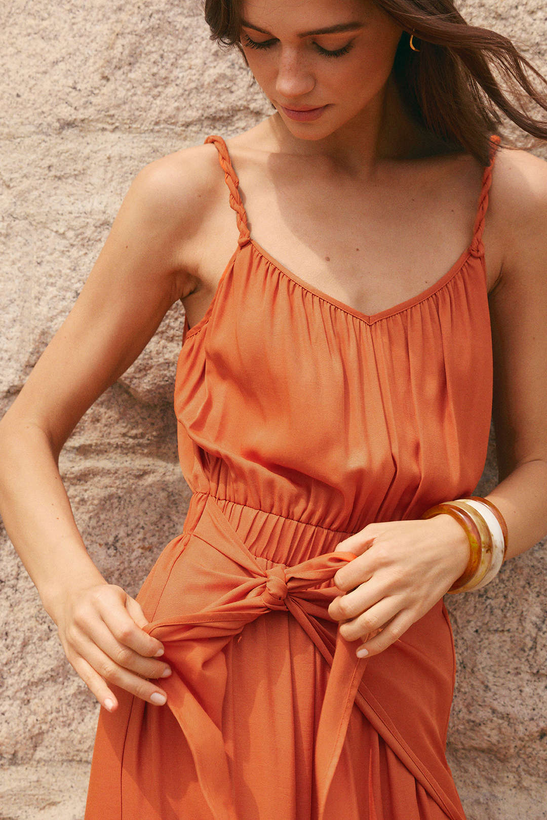 Mouwloze jumpsuit met V-hals, gedraaid detail en knoopdetail