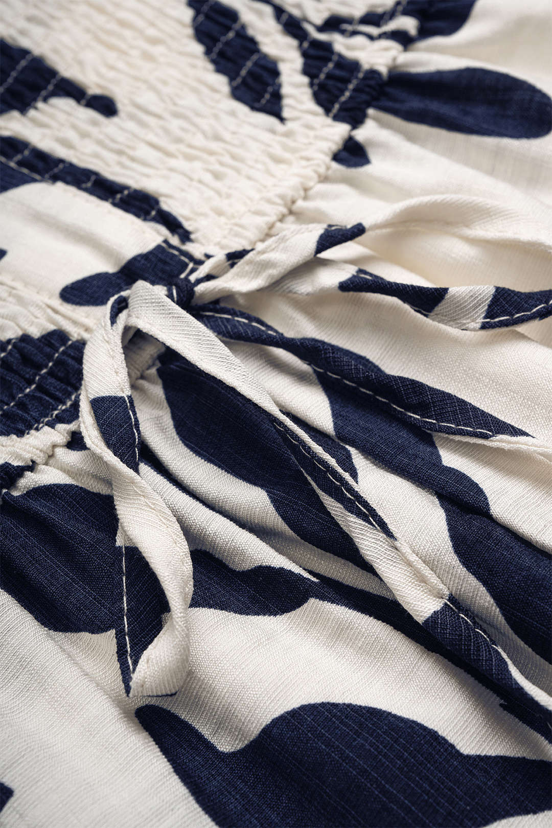 Mouwloze playsuit met knoopjes en smokwerk
