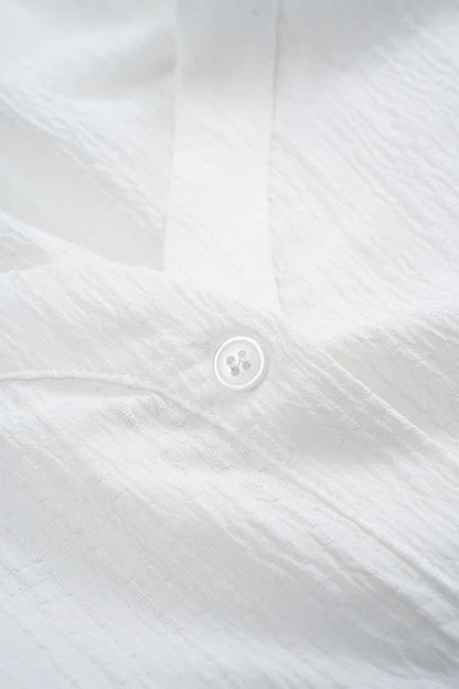 Asymmetrische mouwloze blouse met knoopsluiting en open rug