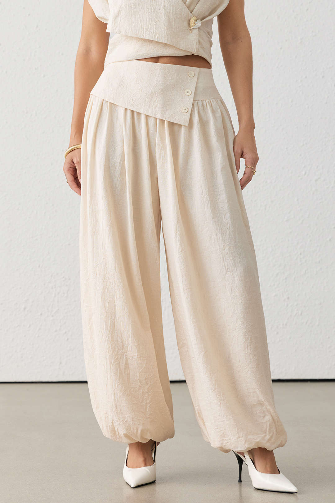 Asymmetrische broek met knoopjes, ruches en wijde pijpen